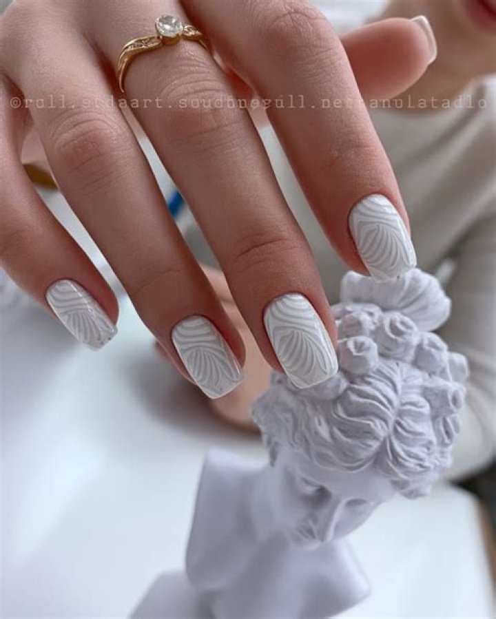 3D sculptural nail art with embellishments including pearls gems and floral appliques