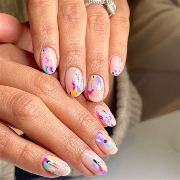 Abstract watercolor ink nail art with blended brushstroke designs in earthy tones